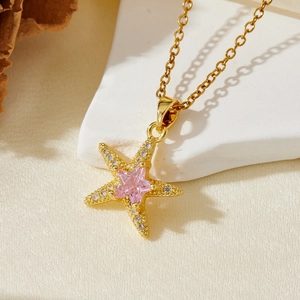 Gold starfish pendant necklace with pink star-cut zircon and sparkling pavé accents