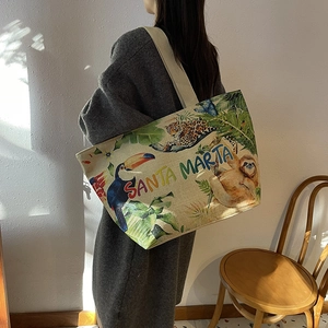 Linen tote bag with tropical jungle print and Santa Marta lettering worn on shoulder
