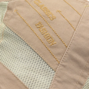 Makro-Detail von khakifarbenem Twill und atmungsaktivem Mesh mit gelber Bestickung