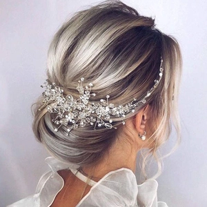 Dettaglio di un accessorio sposa con cristalli e perle su un'acconciatura elegante