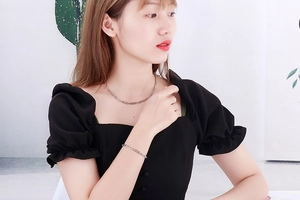 Gros plan d'un ensemble collier et bracelet argenté à maillons trombone sur un mannequin