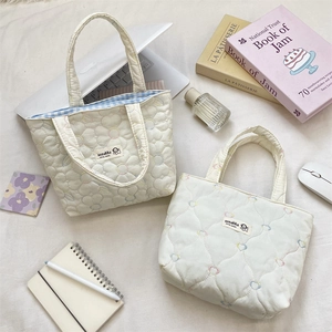 Quilted floral and heart patterns on beige canvas bags with blue checkered lining