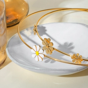 18k gold plated stainless steel daisy choker necklace set in a white ceramic dish