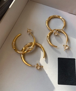 Detailed view of twisted gold-plated hoop earrings with pavé set cubic zirconia stones