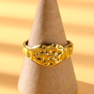 Detail shot of golden irregular lava texture on an adjustable stainless steel ring