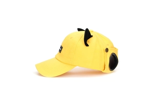 Detail view of bright yellow baseball cap with black cat ears and pilot goggles decoration