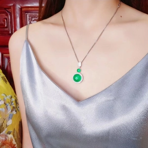 Close-up of elegant green chalcedony pendant necklace worn by a model in satin dress
