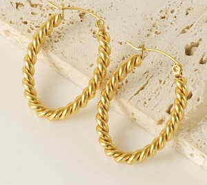 Close-up of gold-plated twisted rope earrings with an elegant textured finish