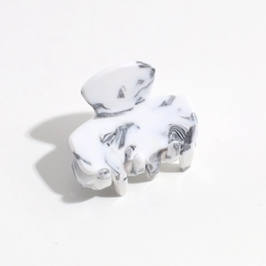 Detail view of stylish leopard marble pattern hair claw clip with silver spring mechanism