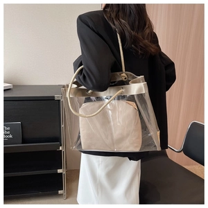 Detail of transparent PVC tote bag with thick woven rope handles and a canvas inner pouch