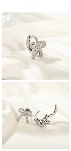 Close-up of silver bow earrings with zircon stones and snap-on mechanism detail