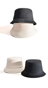 Detailed view of black and beige cotton bucket hats showing fabric texture and stitching