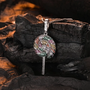 Macro shot of silver lollipop pendant with colorful zircons on dark textured stone