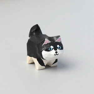 Detailed view of a hand-carved wooden cat figurine with black and white finish