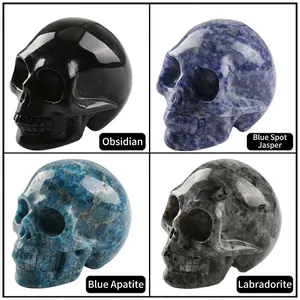 Natural crystal skull carvings in obsidian, sodalite, and larvikite stones set