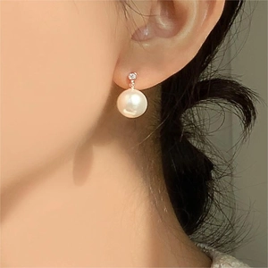 Elegant 925 silver pearl drop earrings with rose gold cubic zirconia accents on model