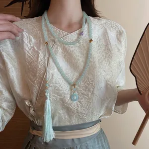 Pale green beaded long necklace with tassel and jade donut pendant in Zen style