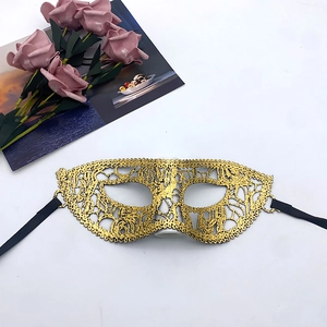 Close-up of gold lace masquerade mask with intricate cutouts and black ribbon ties