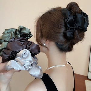 Detailed view of satin rose hair clips in black, green, brown and silver grey colors