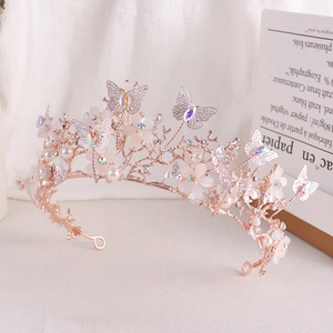 Detail of rose gold bridal crown with pink 3D flowers, crystal butterflies and pearls