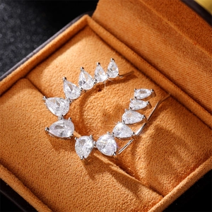 Minimalist pear-shaped zircon crawler earrings in silver finish on a velvet jewelry box