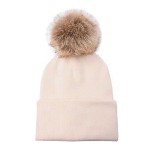 Detail of a beige ribbed knit beanie with a large fluffy brown faux fur pom-pom on top
