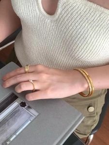 Detail shot of gold-plated geometric bracelets and rings with cubic zirconia and pearls
