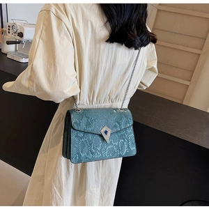 Detail of blue snake pattern shoulder bag featuring sparkling crystal diamond buckle