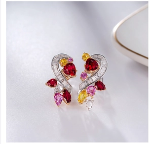 Macro shot of asymmetric multi-colored gemstone earrings with heart-shaped rubies
