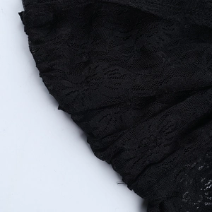 Close-up of intricate floral lace embroidery on black sheer long sleeve dress