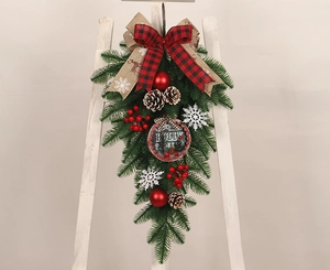 Détail de couronne de Noël inversée avec plaque HOLLY, pommes de pin et ornements