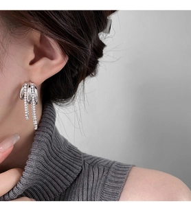 Close-up of zircon multi-layer chain tassel earrings worn by a model in silver