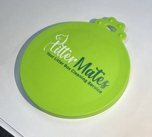 Detail of green silicone pet food can lid with cat paw hanging hole and logo