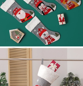 Detail view of knitted Christmas stockings with Santa, reindeer, and penguin embroidery