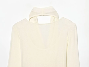 Detail of white knit top with unique cutout cross neckline and ribbed sleeve texture