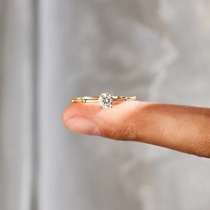 Macro shot of a gold bead-detailed ring with a brilliant round-cut sparkling stone