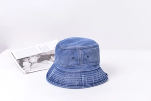 Détail d'un chapeau bob en denim délavé avec œillets et surpiqûres renforcées