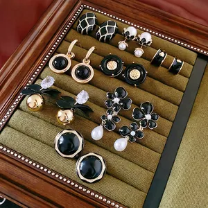 Elegant black enamel and gold earrings set with pearls in a luxury velvet box