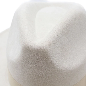 Close-up of the cream white crown on a suede wide-brim felt hat with refined texture