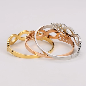 Detailed macro view of infinity bangles in gold, rose gold and silver with hollow patterns