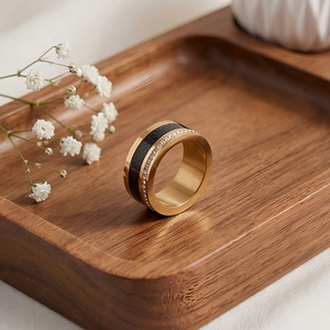 Detailed view of a gold titanium ring with black inlay and rows of white cubic zirconia