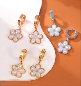 Detailed macro view of floral pearl earrings with iridescent petals in gold finish