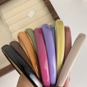 Macro shot of colorful glossy headbands displayed in a wide range of pastel macaron shades