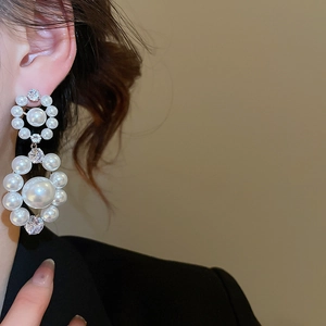 Détail de boucles d'oreilles élégantes en argent avec perles rondes et zircons brillants