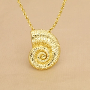 Makroaufnahme vom goldenen Nautilus-Anhänger mit Spiralstruktur an der Kordelkette