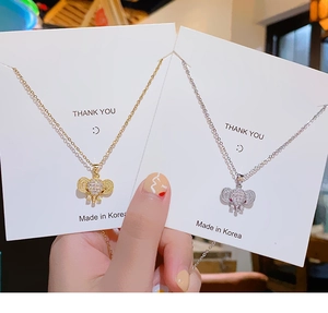 Detail of gold and silver elephant necklaces featuring sparkling crystal and red gem eyes