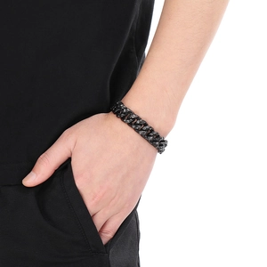 Detail of chunky black hammered stainless steel Cuban link bracelet on male wrist