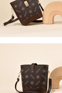 Detail of dark brown bucket bag with gold hardware and MOCKDE monogram pattern