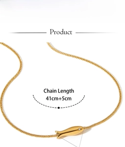 Detail of golden fish pendant necklace with white zircon eye and adjustable wheat chain