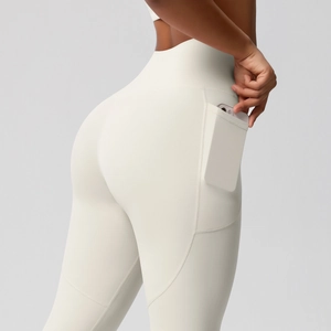 Detail view of high-waist cream yoga leggings with a functional side pocket for phone